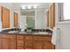 Well-lit bathroom with double vanity, wood cabinets, granite countertop, and shower with glass door at 92 S Devinney St, Golden, CO 80401