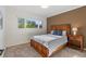 The bedroom boasts a natural wood bed frame, soft carpeting, and a window letting in ample sunlight at 92 S Devinney St, Golden, CO 80401