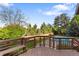 Wooden deck overlooking a lush backyard with mature trees, a privacy fence, and a refreshing pool at 92 S Devinney St, Golden, CO 80401