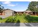 Well-maintained home featuring a manicured lawn, mature trees, and brick exterior at 92 S Devinney St, Golden, CO 80401