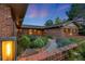 Charming brick home featuring a beautifully landscaped front yard and warm exterior lighting at 92 S Devinney St, Golden, CO 80401
