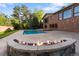 Outdoor living space featuring a stone fire pit, pool, and brick home exterior for entertaining at 92 S Devinney St, Golden, CO 80401