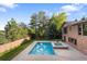 Backyard view features a sparkling pool, jacuzzi, and brick home exterior, perfect for outdoor relaxation at 92 S Devinney St, Golden, CO 80401