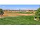 Scenic golf course view with lush green grass, a pond, and a view of the community at 8525 E 149Th Dr, Thornton, CO 80602