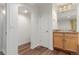 Hallway leading to a bathroom, featuring wood floors and an arched doorway at 8525 E 149Th Dr, Thornton, CO 80602