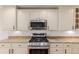 Kitchen featuring stainless steel oven and microwave along with white cabinets and granite countertops at 8525 E 149Th Dr, Thornton, CO 80602