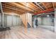 Unfinished basement with wood flooring, exposed beams, and stairway at 613 Rio Rancho Way, Brighton, CO 80601