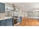Stylish kitchen with stainless steel range, white countertops, and hardwood floors, open to the living area at 613 Rio Rancho Way, Brighton, CO 80601