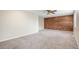 Spacious living room with a wood accent wall and neutral carpet at 613 Rio Rancho Way, Brighton, CO 80601