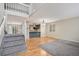Bright living room features hardwood floors, staircase, and seamless open floor plan to kitchen with breakfast bar at 613 Rio Rancho Way, Brighton, CO 80601