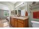 Bathroom featuring double sinks with tan countertop and wood cabinets near the bedroom at 7130 Simms St # 206, Arvada, CO 80004