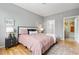 Bedroom featuring a bed, wood floors, and bathroom access at 7130 Simms St # 206, Arvada, CO 80004