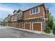 Row of townhomes featuring private garages and stone accents at 7130 Simms St # 206, Arvada, CO 80004