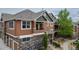 Exterior view of a well-maintained townhome with stone and siding facade at 7130 Simms St # 206, Arvada, CO 80004