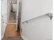 Hallway featuring tile floors, an open doorway to the garage, and a white handrail at 7130 Simms St # 206, Arvada, CO 80004