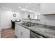 Kitchen featuring stainless steel sink, white cabinets, and granite countertop next to the dining area at 8701 Huron St # 1-212, Thornton, CO 80260