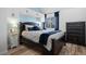 Main bedroom features a large bed, dresser, hardwood floors, and stylish blue accents at 8701 Huron St # 1-212, Thornton, CO 80260