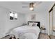 Bedroom featuring a ceiling fan, window, and a comfortable bed with stylish pillows and blanket at 2700 S Holly St # 107, Denver, CO 80222
