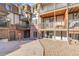 Multi-level condo complex featuring balconies, brick accents and stone landscaping at 2700 S Holly St # 107, Denver, CO 80222