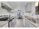 Galley kitchen with stainless steel appliances and updated countertops and access to eat-in area at 2700 S Holly St # 107, Denver, CO 80222