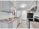 Kitchen showcasing stainless steel appliances, and white cabinets with granite countertops at 2700 S Holly St # 107, Denver, CO 80222