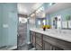 Bright bathroom featuring a double vanity sink, modern fixtures, and a stylish walk-in shower with pebble flooring at 2305 Quitman St, Denver, CO 80212