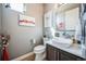 Modern half bathroom featuring neutral walls, wood-look floors, framed art, and vanity sink at 2305 Quitman St, Denver, CO 80212
