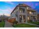 Striking modern home featuring stone accents and a private balcony at sunset at 2305 Quitman St, Denver, CO 80212