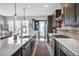 Bright kitchen with stainless appliances, long island with sink, hardwood floors, and sliding glass doors to the backyard at 2305 Quitman St, Denver, CO 80212