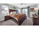 Well-lit bedroom with a large bed, side tables, wood dressers, and a door to a balcony at 2305 Quitman St, Denver, CO 80212