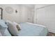 Bright bedroom with large closet and serene blue bedding complemented by decorative wall art and open doorway at 2985 W 46Th Ave, Denver, CO 80211