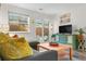 Cozy living room with a comfortable gray couch, colorful pillows, and a sliding glass door to the outside at 2985 W 46Th Ave, Denver, CO 80211