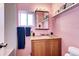 Bathroom featuring pink walls, a vanity, mirror, and a window at 2852 W Ellsworth Ave, Denver, CO 80219