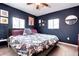 Bedroom with blue walls, floral bedding, a ceiling fan, and natural light from two windows at 2852 W Ellsworth Ave, Denver, CO 80219