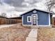 Charming blue home featuring a covered parking area and a well-maintained front yard at 2852 W Ellsworth Ave, Denver, CO 80219