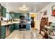 Kitchen featuring green cabinets, stainless steel appliances, and a view into the laundry room at 2852 W Ellsworth Ave, Denver, CO 80219