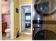 A well-lit laundry area offers a modern stacked washer and dryer next to a bathroom and bedroom at 2852 W Ellsworth Ave, Denver, CO 80219