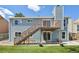 Exterior view of the home featuring a wooden deck and stairs leading down to a grassy backyard at 17476 E Bellewood Cir, Aurora, CO 80015