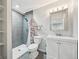 Bathroom with a tiled shower, modern vanity, toilet, and decorative mirror with lighting at 17476 E Bellewood Cir, Aurora, CO 80015