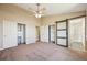 Bright bedroom with ceiling fan, double closets, and barn door access to renovated bathroom at 17476 E Bellewood Cir, Aurora, CO 80015