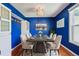 Bright blue dining room with modern table, chairs, and light fixture at 17476 E Bellewood Cir, Aurora, CO 80015
