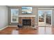 Close-up of the living room fireplace with wood floors, mantle, and a sliding glass door to the deck at 17476 E Bellewood Cir, Aurora, CO 80015