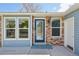 Inviting entryway showcasing a blue door, brick accents, and ample natural light from the windows at 17476 E Bellewood Cir, Aurora, CO 80015
