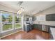 This bright kitchen features stainless steel appliances, gray cabinets, pendant lighting and wood floors at 17476 E Bellewood Cir, Aurora, CO 80015
