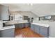 Open kitchen features stainless steel appliances, gray cabinets, and wood floors at 17476 E Bellewood Cir, Aurora, CO 80015