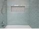 Close up on shower showcasing neutral tile and a built in storage nook at 17476 E Bellewood Cir, Aurora, CO 80015