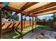 Inviting backyard with wooden pergola, seating area, green lawn, and a tall wooden fence at 3903 W Nevada Pl, Denver, CO 80219