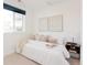 Bright bedroom featuring a cozy bed with white linens, neutral decor, and natural light from the window at 3903 W Nevada Pl, Denver, CO 80219