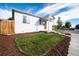 Quaint home featuring fresh landscaping, including a grassy lawn and mulch beds, under a bright blue sky at 3903 W Nevada Pl, Denver, CO 80219