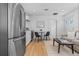 Bright, open living room featuring a modern kitchen, hardwood floors, neutral-toned furniture and white walls at 3903 W Nevada Pl, Denver, CO 80219